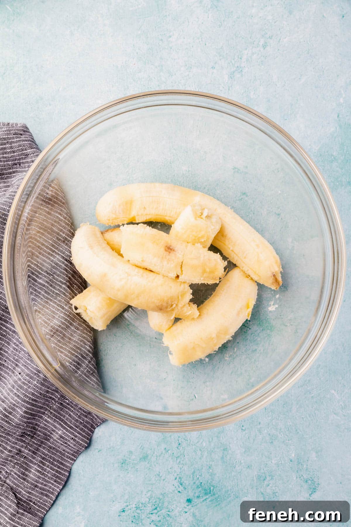 Ripe bananas in a large glass mixing bowl.