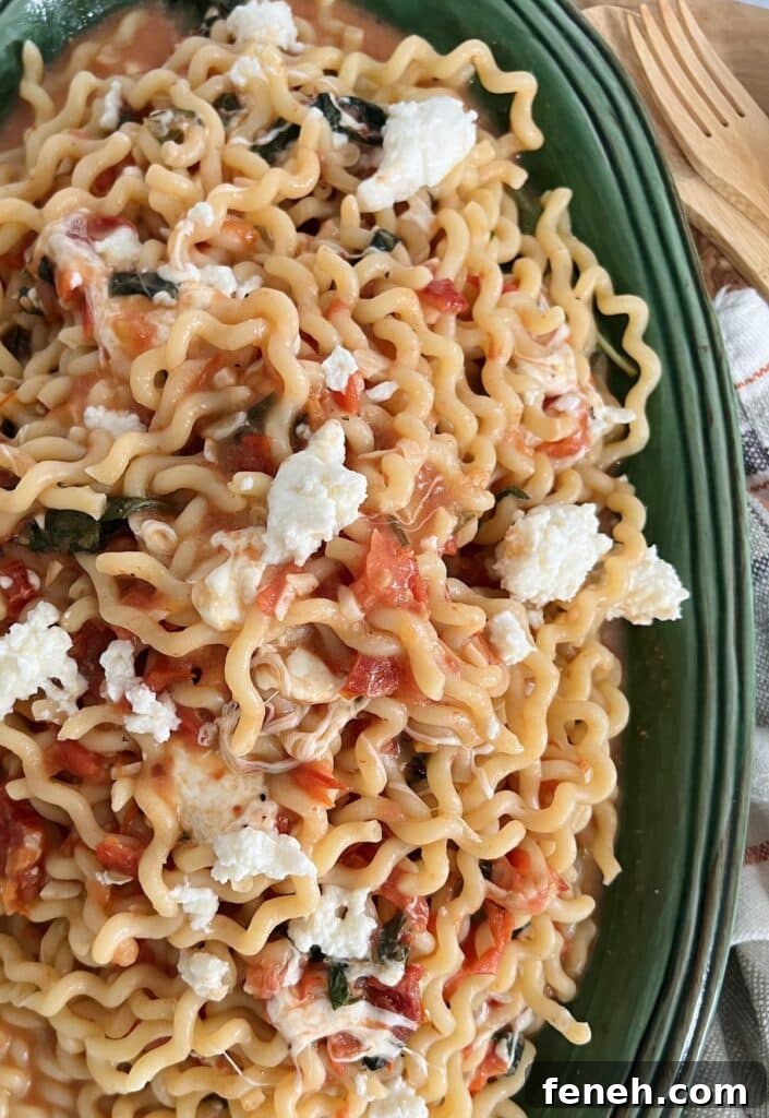 Overhead view of fusilli sorrentina on green platter.