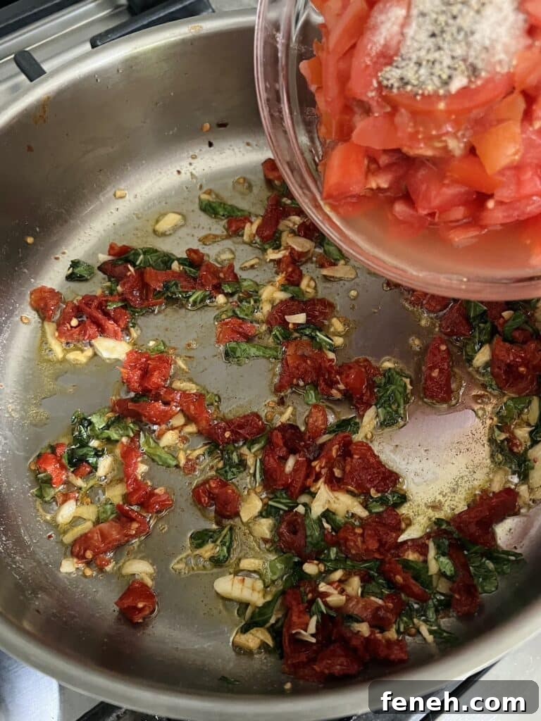 Fresh Tomatoes about to be added to pan with dried tomatoes, garlic, basil and butter.