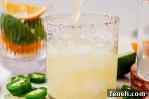 pouring a spicy skinny margarita into a glass of ice