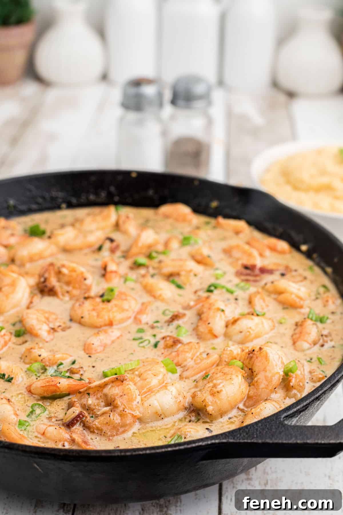 Side shot of a skillet of Creole shrimp in cream sauce.