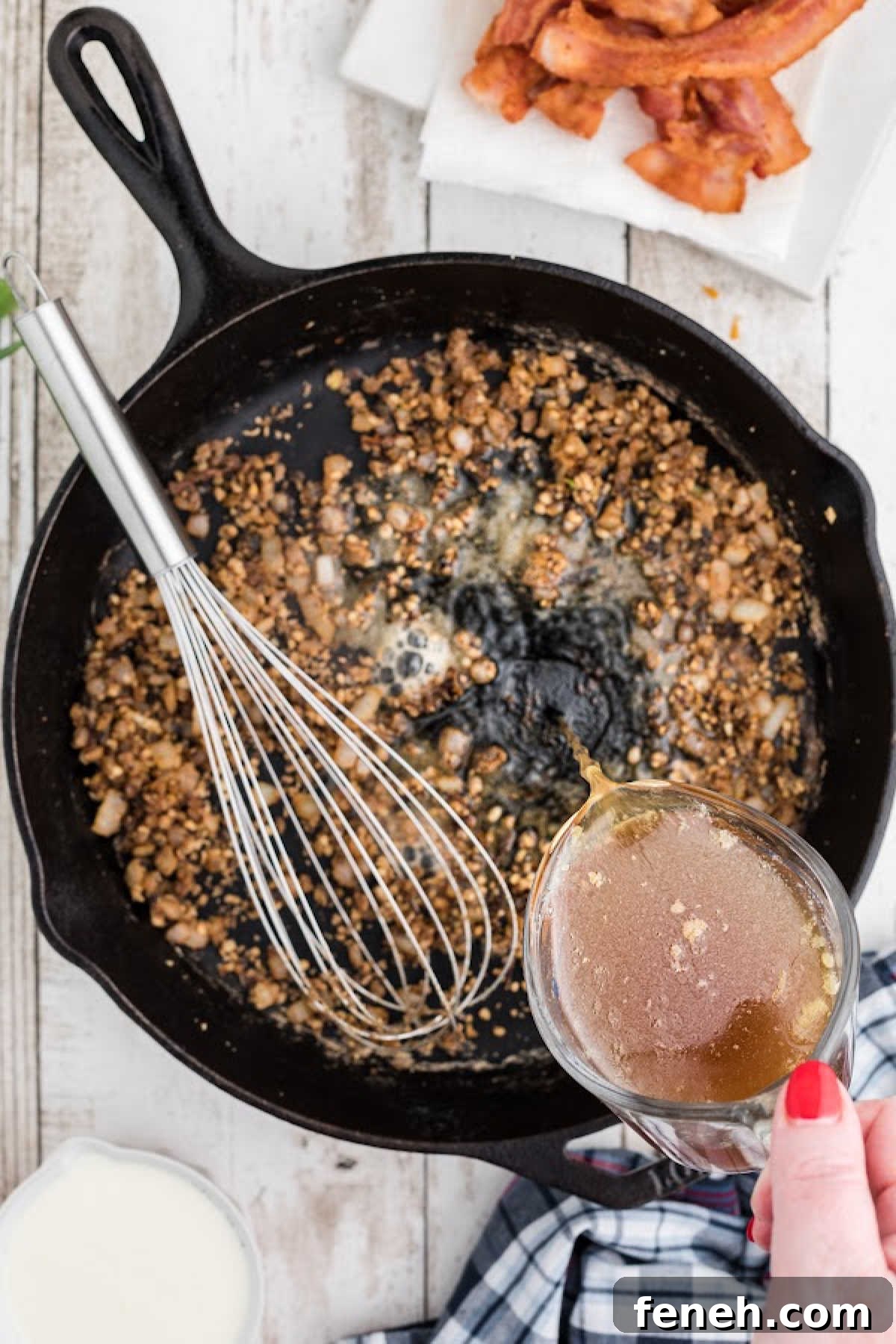 Chicken broth being poured into a cast iron skillet.