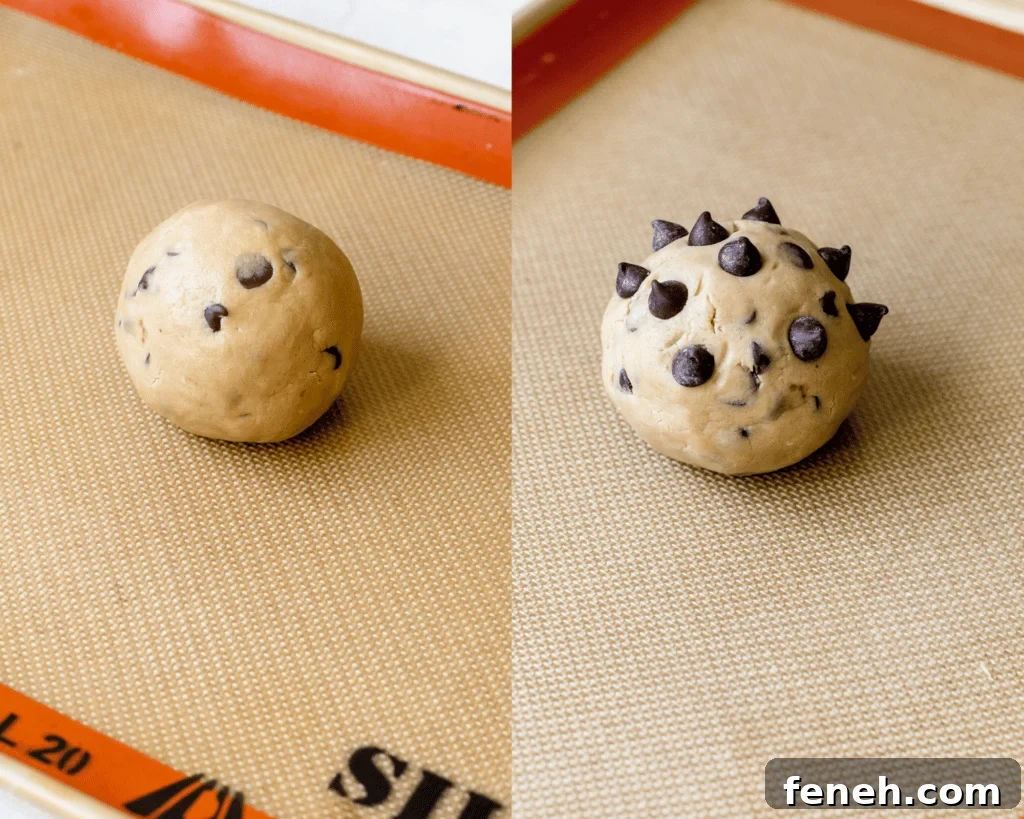a cookie dough ball on a baking sheet topped with chocolate chips.