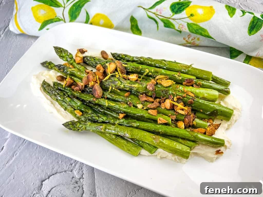 Cooked asparagus topped with pistachios on a bed of mascarpone cheese.