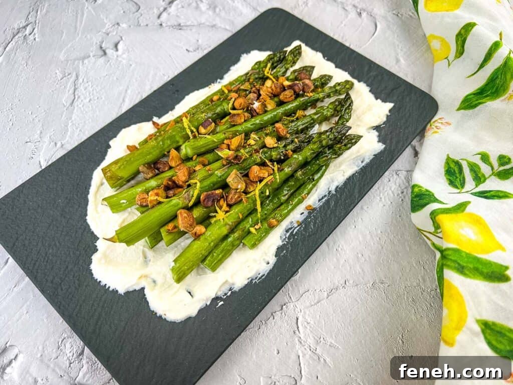 A horizontal shot of Asparagus with Mascarpone on a black platter.