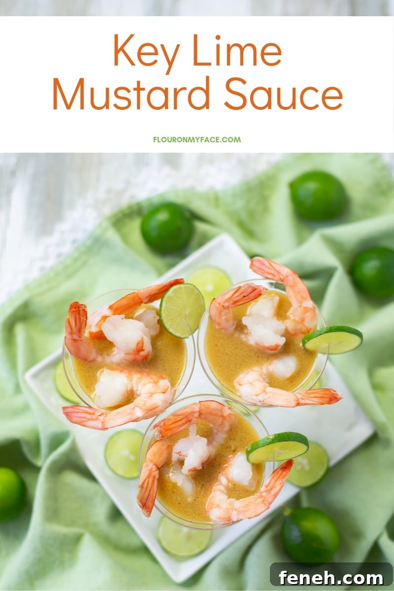 3 mini plastic martini appetizer glasses filled with Key Lime Mustard Sauce and boiled pink shrimp on a green cloth napkin with fresh key limes