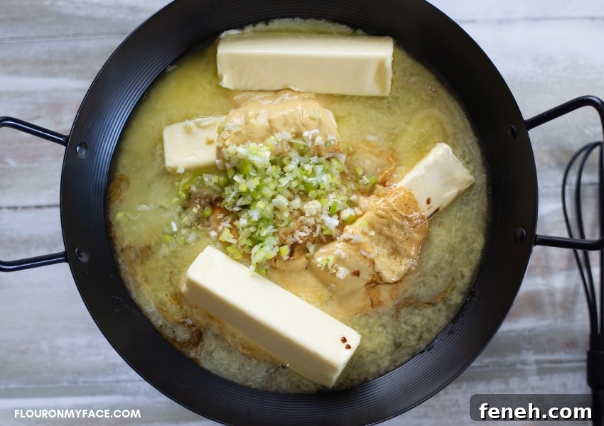 Seafood Mustard Dipping Sauce ingredients in a black skillet cooking on a burner.