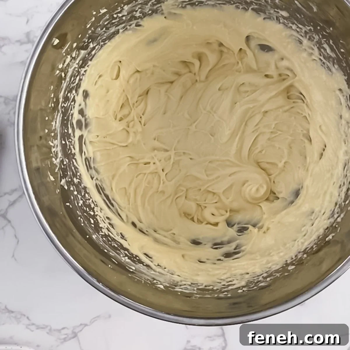 butter, sugar, eggs, vanilla mixed together in a bowl.