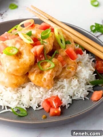 A plate of bang bang shrimp served over rice.