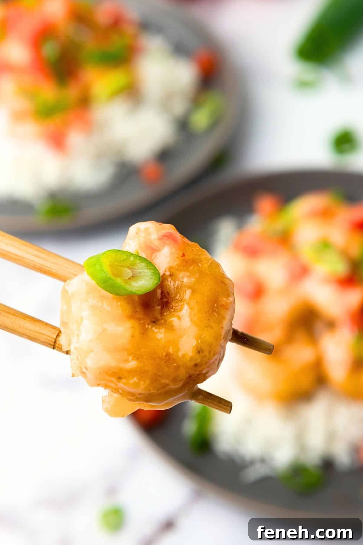 Chopsticks holding up a piece of shrimp 