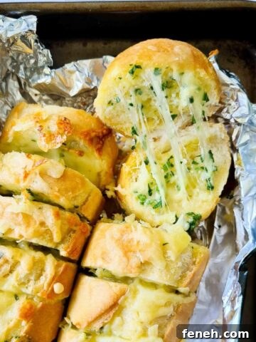 Close up of strechy cheesy garlic bread straight out of the oven