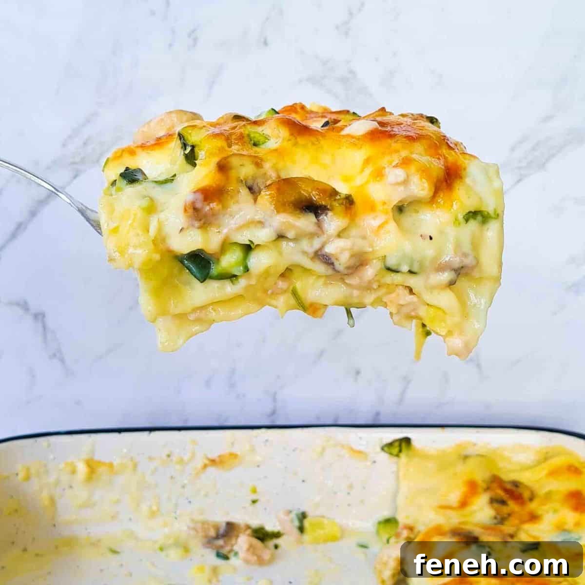 Side view of slice of white lasagna being scooped out of baking dish