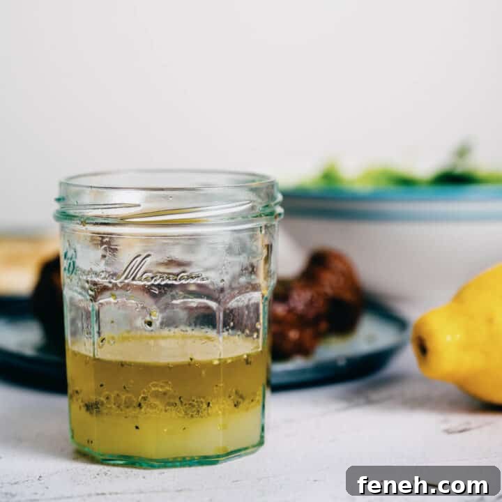 a glass jar filled with Greek olive oil and lemon sauce.