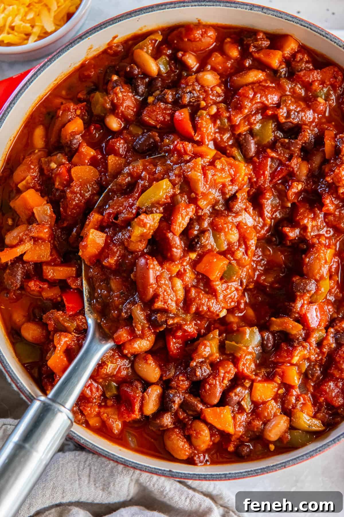 A large pot of three bean chili on a white tabletop.