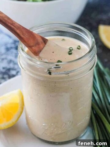 Small wooden spoon in a jar of vegan ranch dressing.