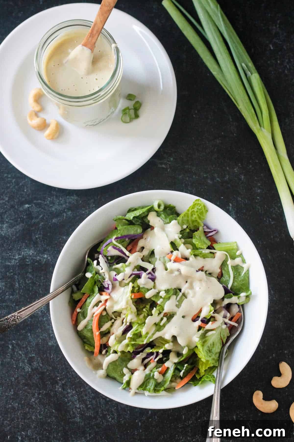 Jar of sesame salad dressing next to a bowl of salad drizzled with the same dressing.