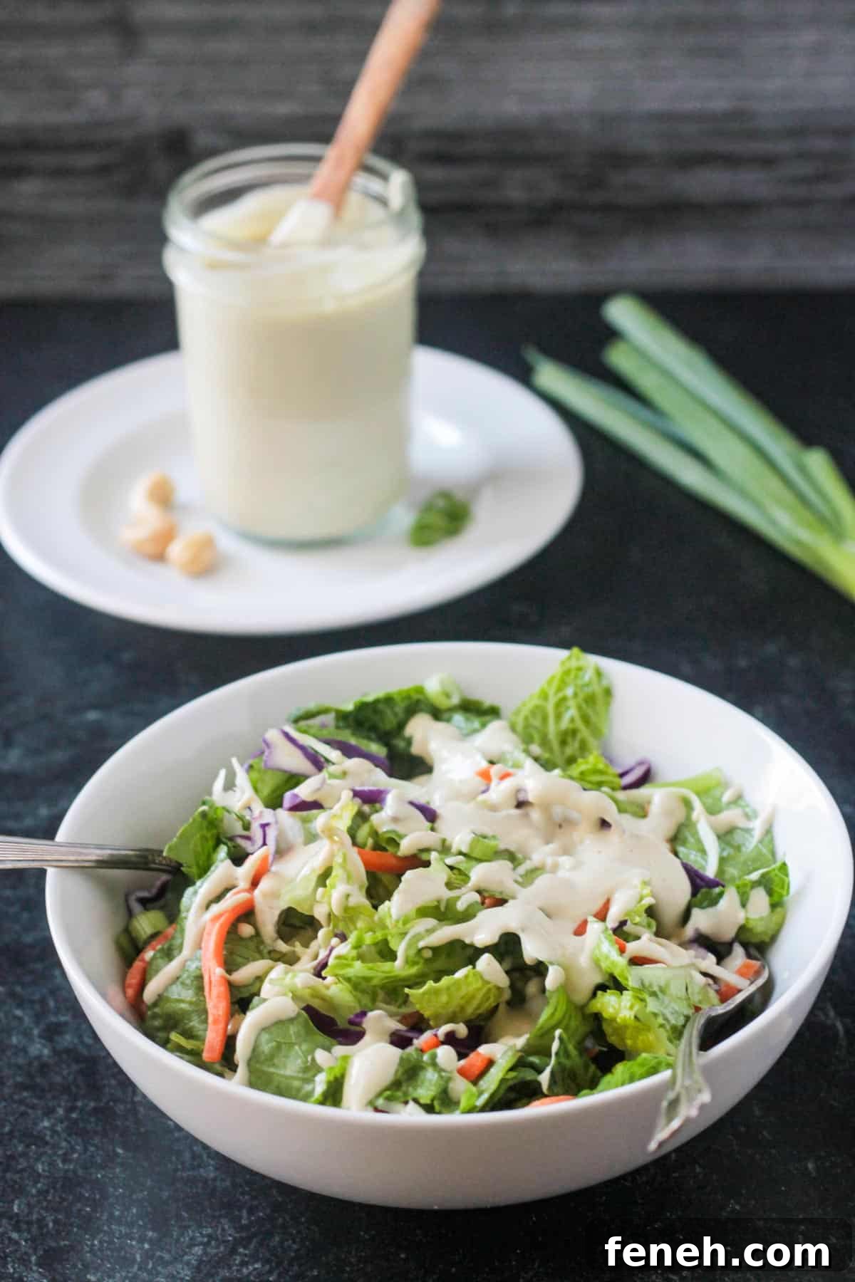 Fork in a salad bowl topped with sesame salad dressing.
