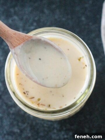 Spoonful of sauce being lifted from a jar.