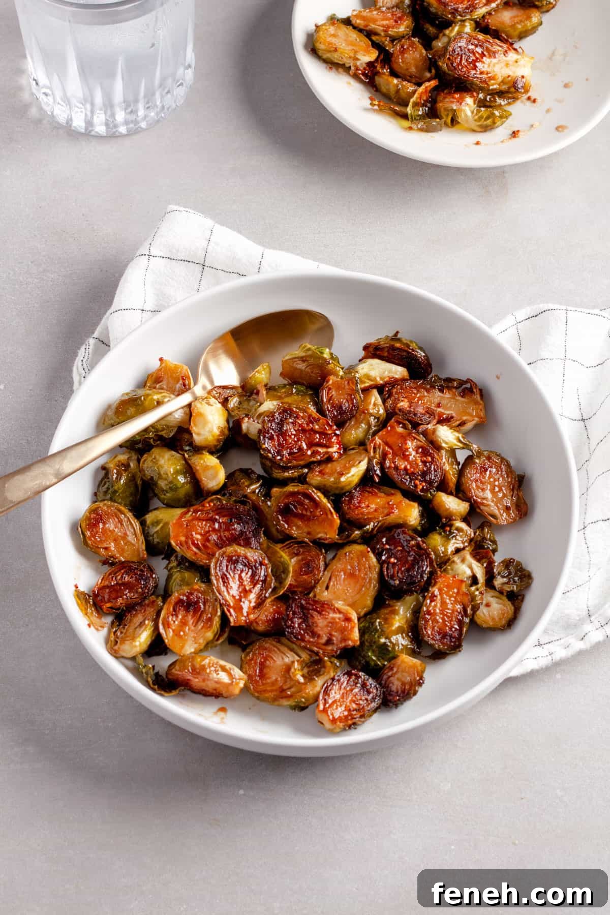 A serving platter of maple balsamic Brussels sprouts with a small bowl in the background.