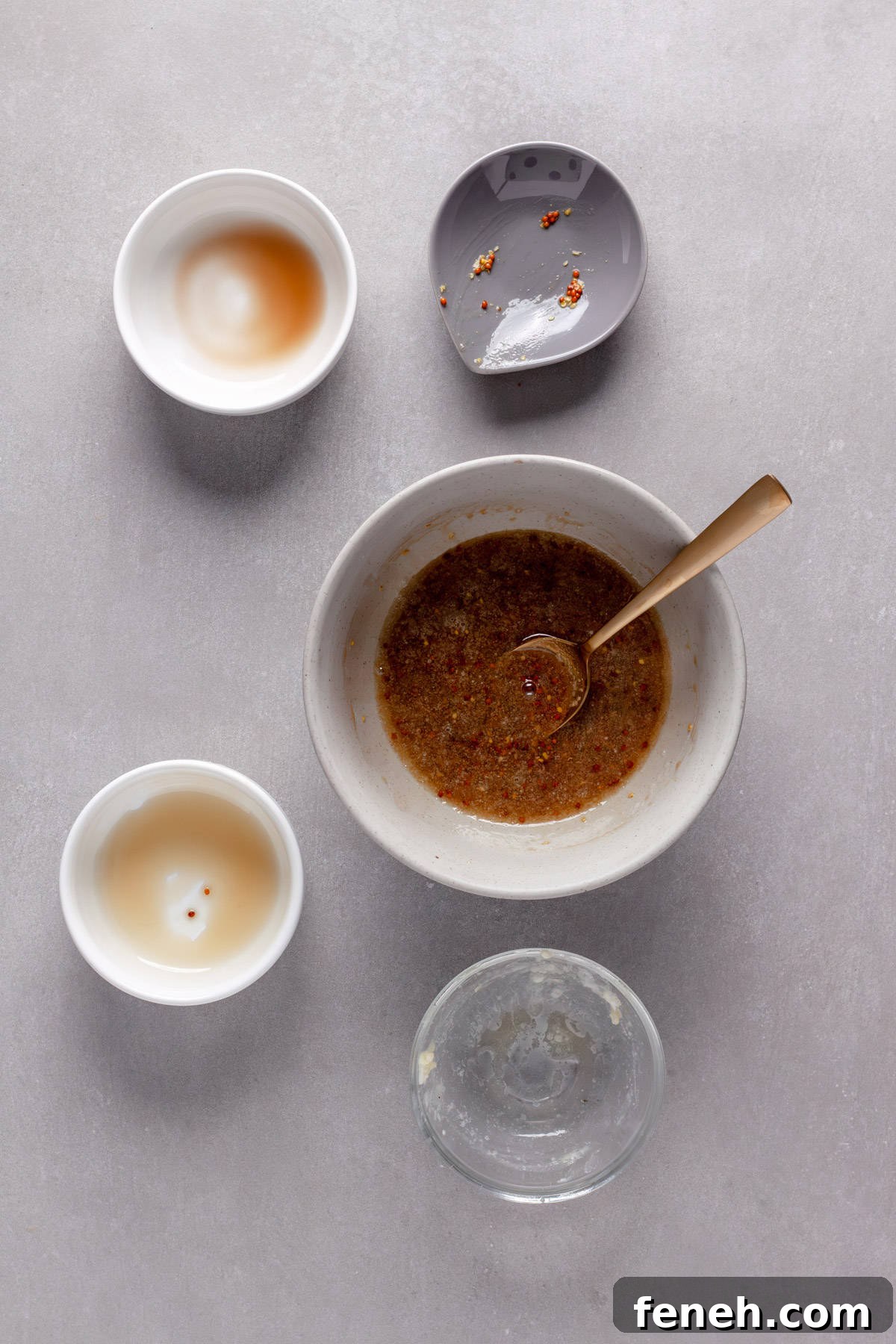 A sauce of mustard, maple, balsamic and melted butter getting stirred in a small bowl.