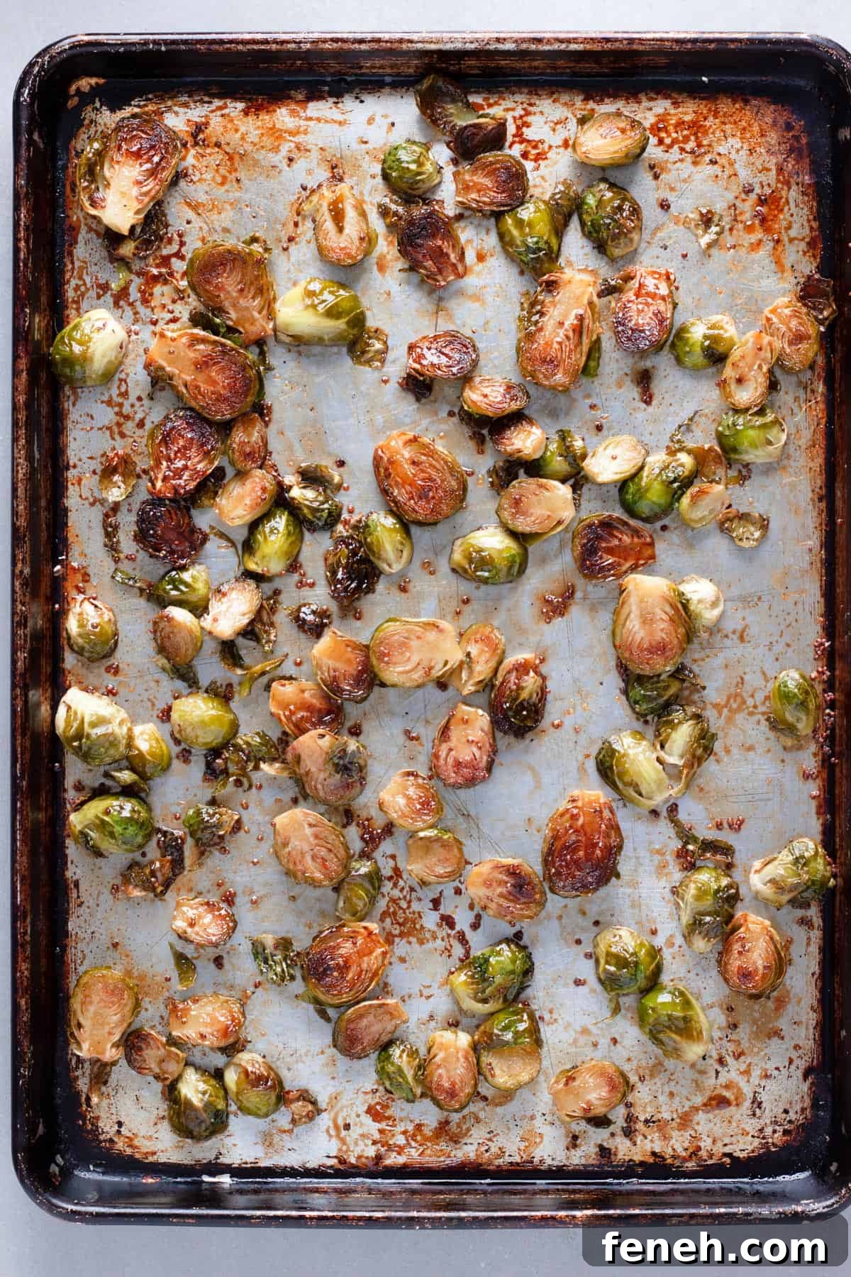 Maple balsamic brussels sprouts on a baking sheet roasted to golden brown.