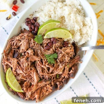 A white oval bowl with shredded barbacoa beef with rice and black beans.