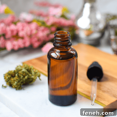 A picture of a bottle of CBD oil with fresh cananabis buds.