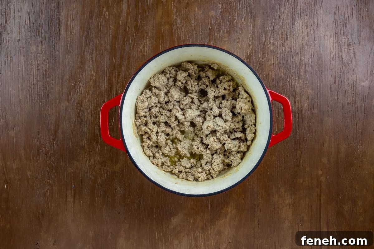 Ground chicken cooked in olive oil a red dutch oven.