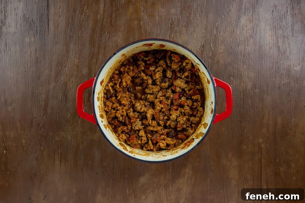 Cooked chicken chili in the red dutch oven.