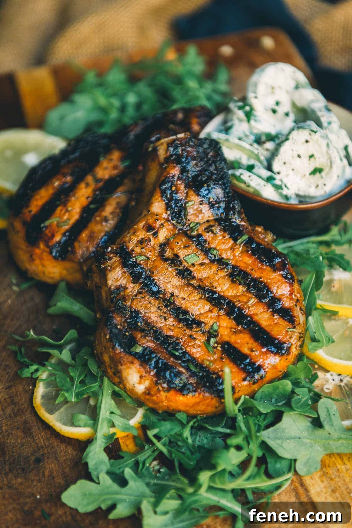 Close up of juicy grilled pork chops with grill marks waiting to be sliced into. 