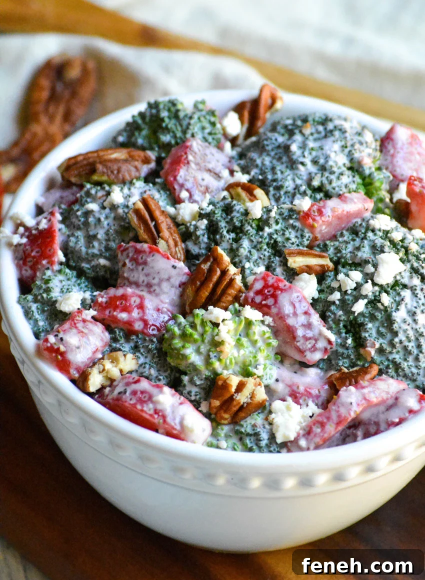 creamy strawberry broccoli salad studded with pecans and served in a white bowl