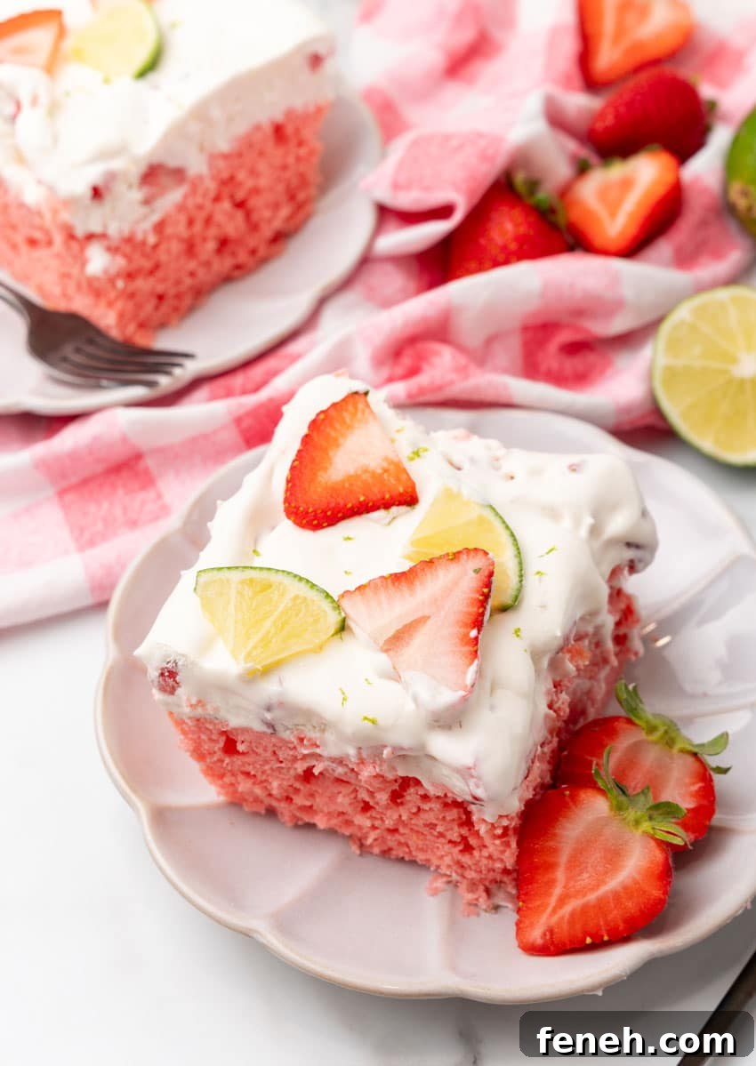 slices of strawberry margarita poke cake on small white dessert plates