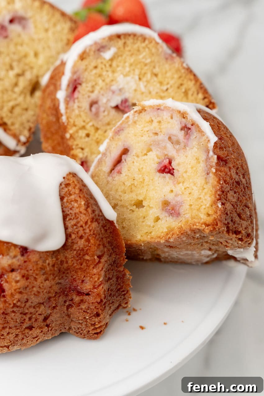 slices of strawberry lemon yogurt cake on a white cake stand