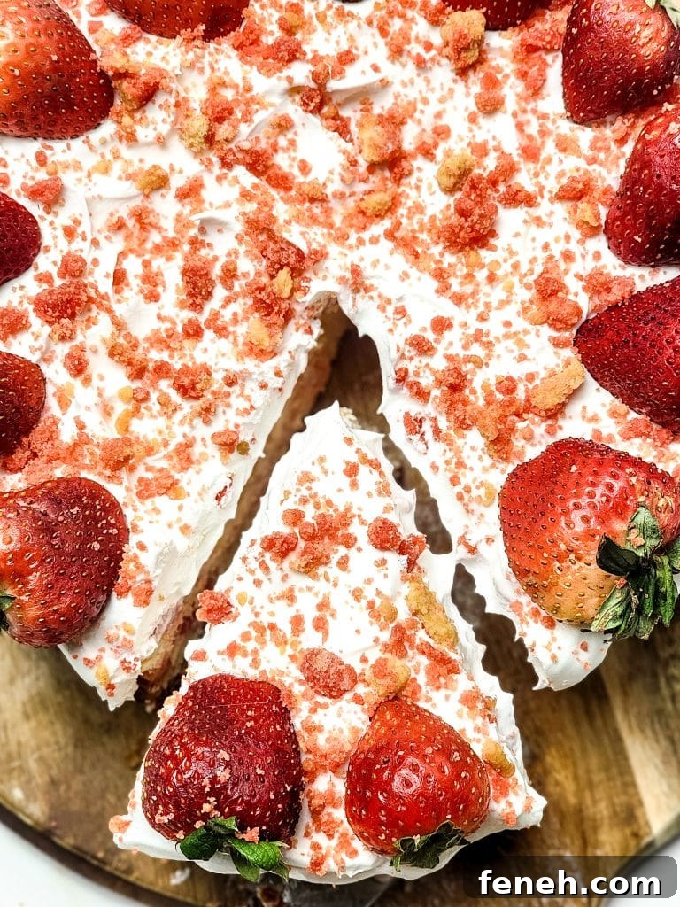 a server removing a slice of strawberry crunch cheesecake from a wooden cutting board