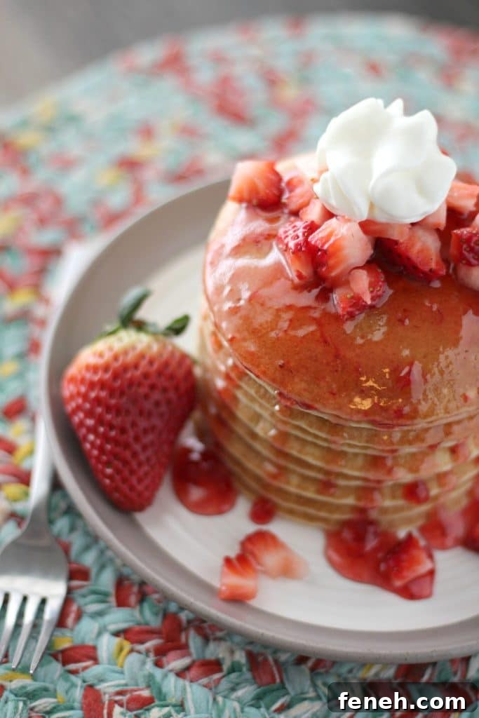 a stack of strawberry shortcake pancakes on a white plate