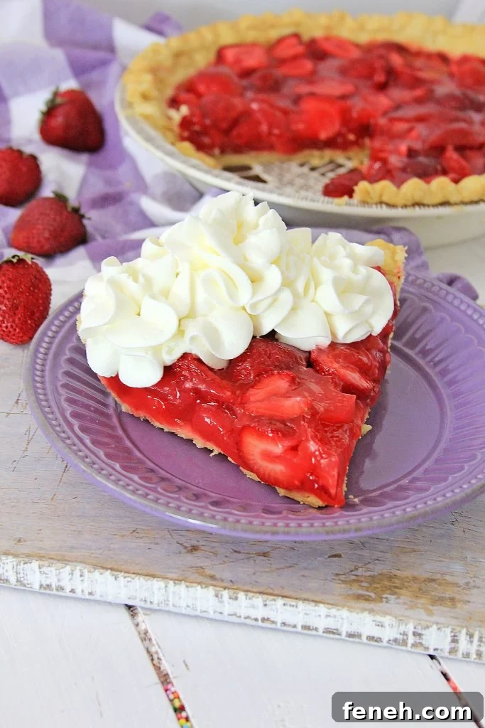 a slice of strawberry jello pie on a purple plate, topped with dollops of whipped cream