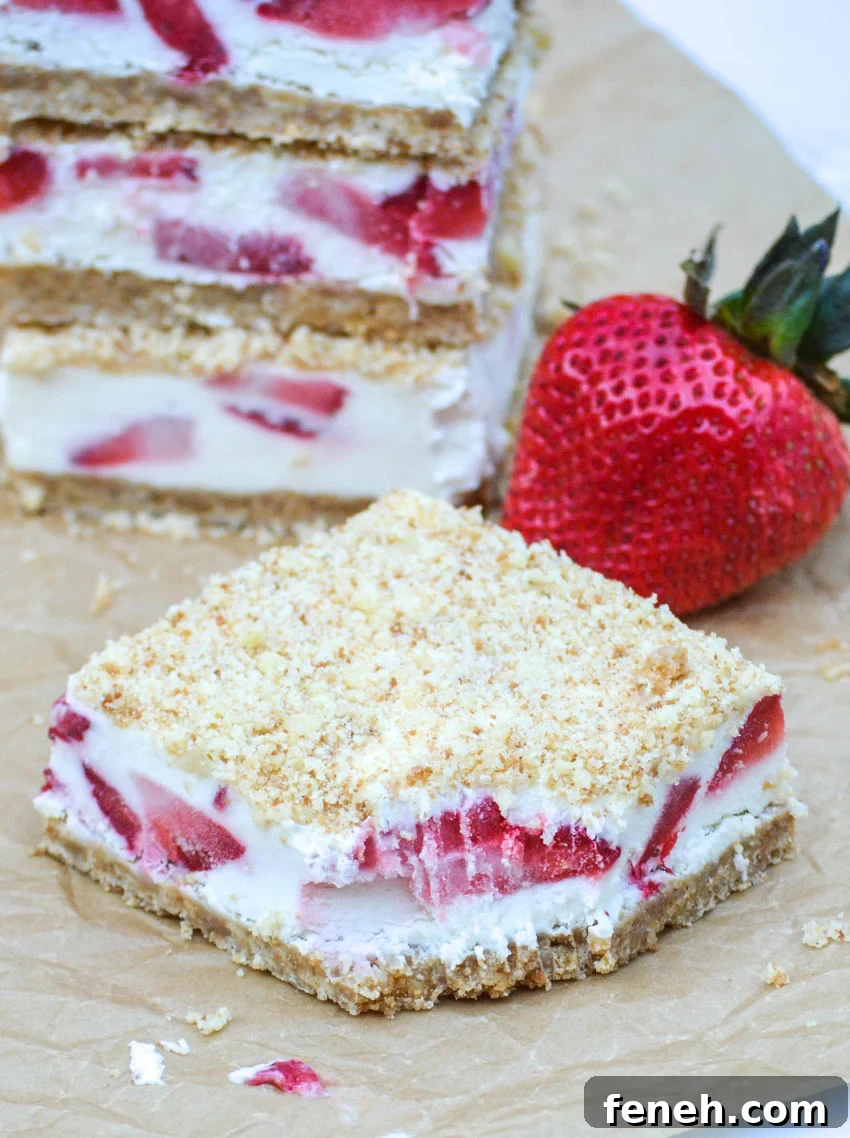 strawberry crunch bars cut into squares on a sheet of brown parchment paper