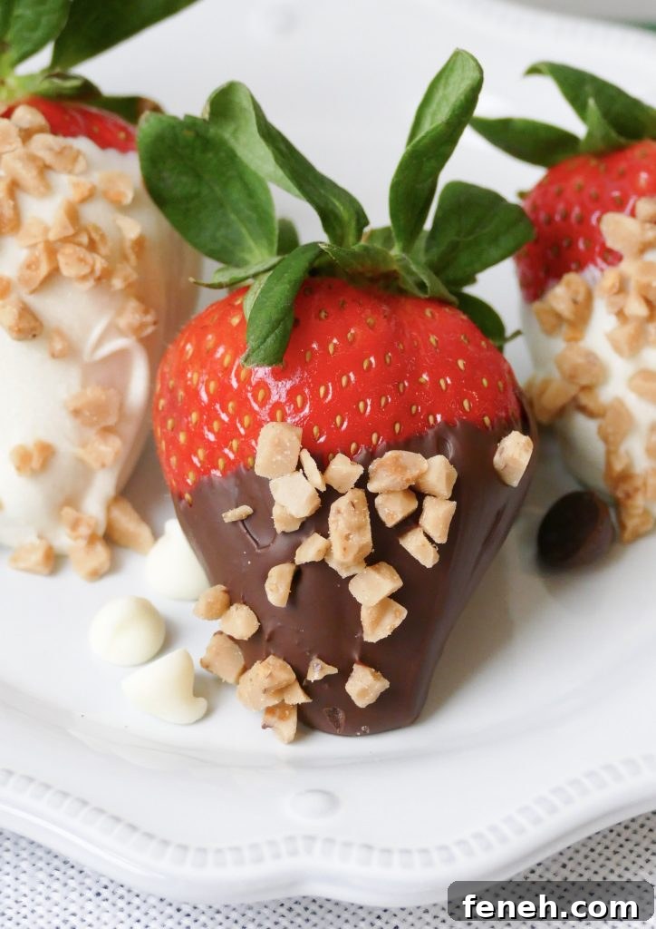 hand dipped chocolate covered strawberries sprinkled with toffee chips and served on a white plate