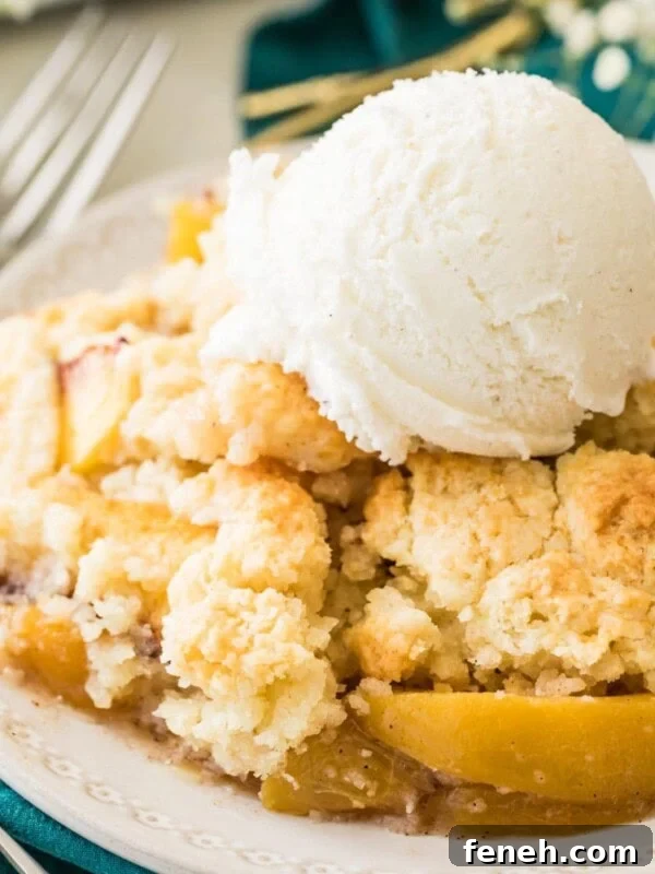 bowl of peach cobbler topped with vanilla ice cream