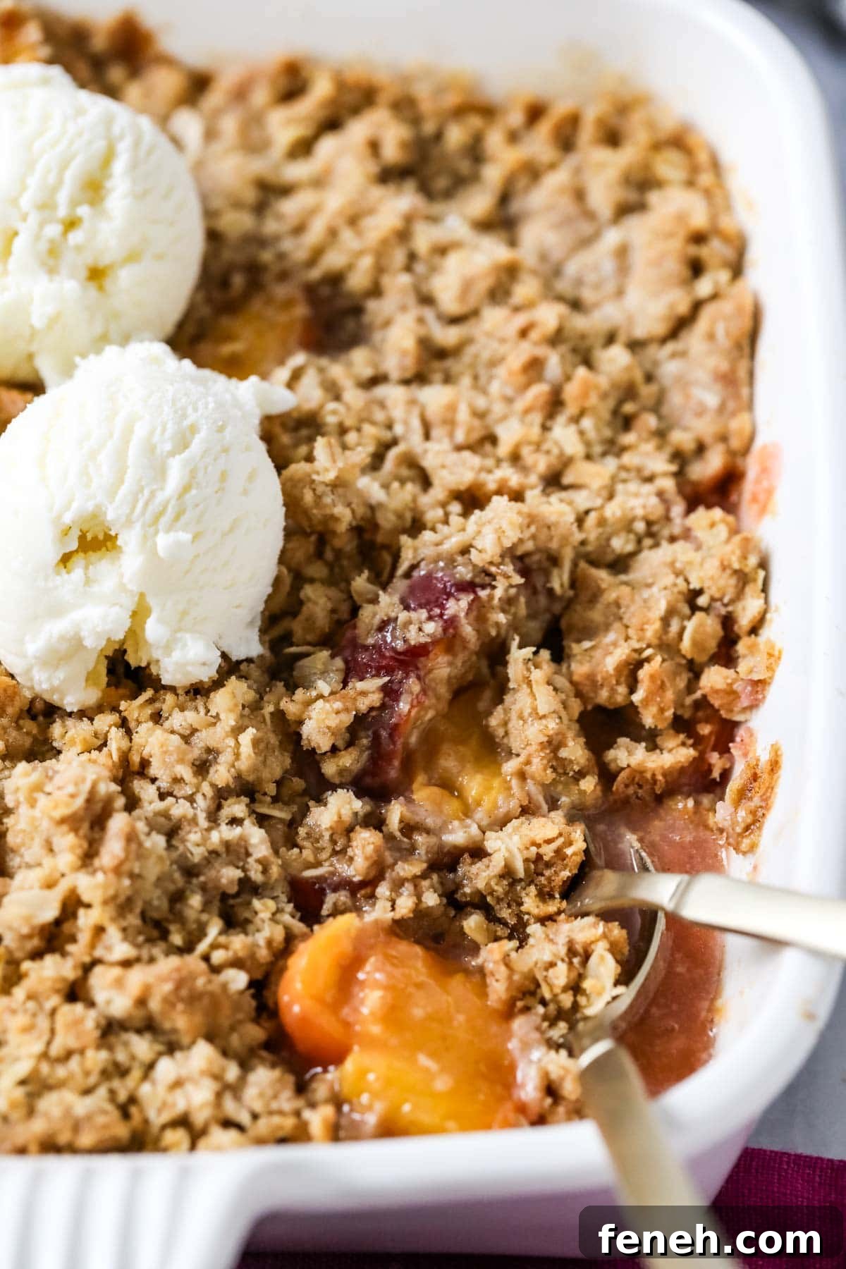 Close-up view of peach crisp in a casserole dish.