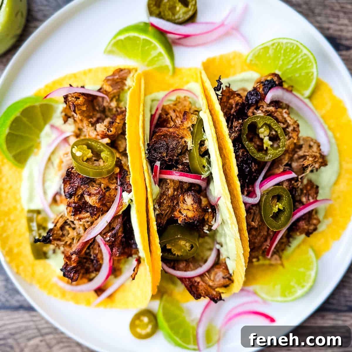 Carnitas street tacos with tender pulled pork, jalapeño slices, red onions, and avocado lime crema on corn tortillas.