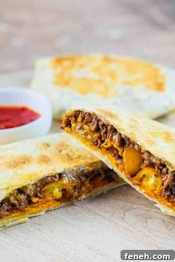 A crispy copycat Taco Bell crunchwrap cut in half and placed on a serving board with a side of homemade salsa for dipping.