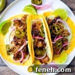 Carnitas street tacos with tender pulled pork, jalapeño slices, red onions, and avocado lime crema on corn tortillas.