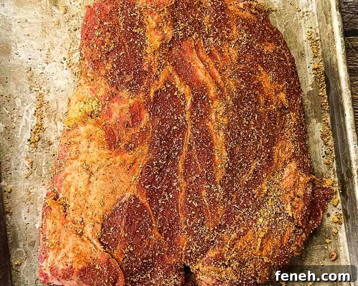The pork shoulder covered in spice rub.