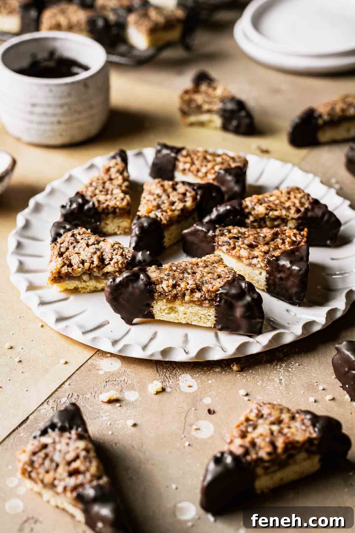 Nussecken bars dipped in chocolate on a white fluted plate.