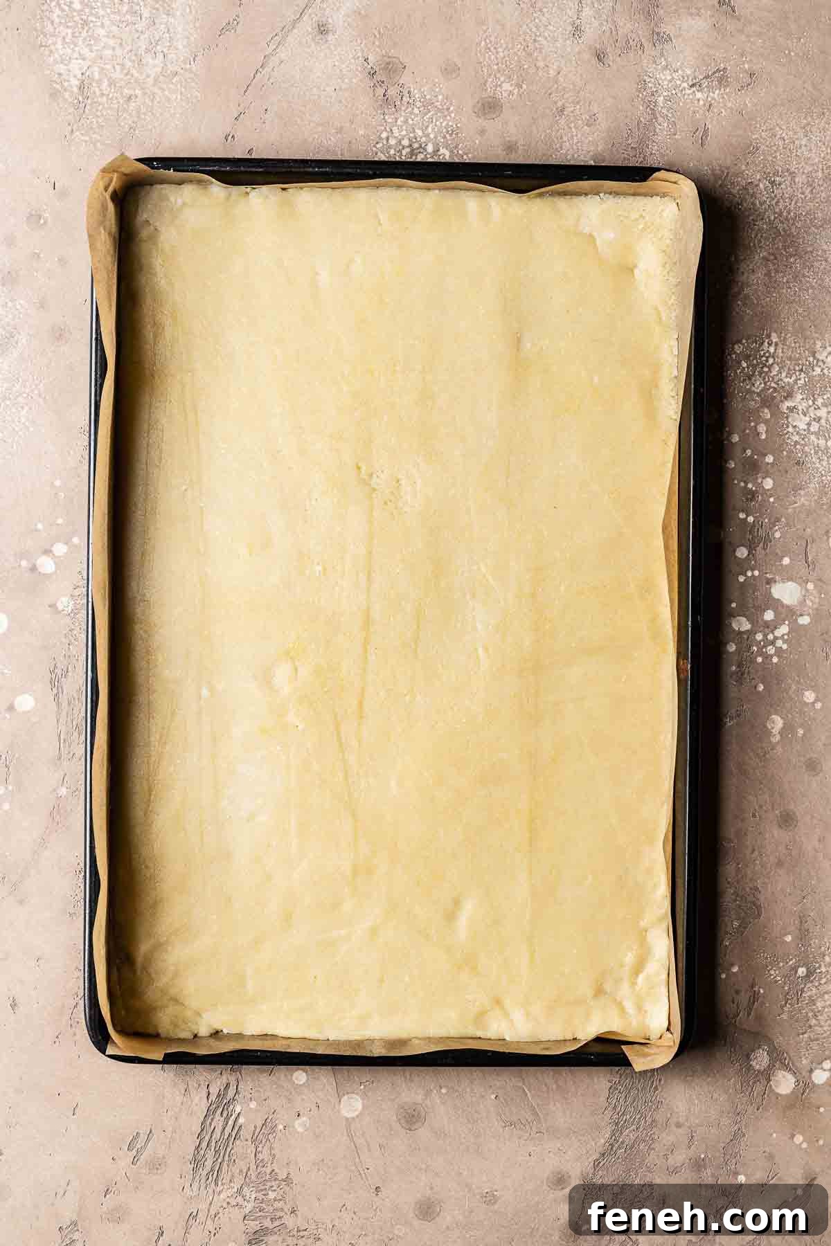 A jelly roll pan with rolled out shortcrust pastry dough for nussecken.