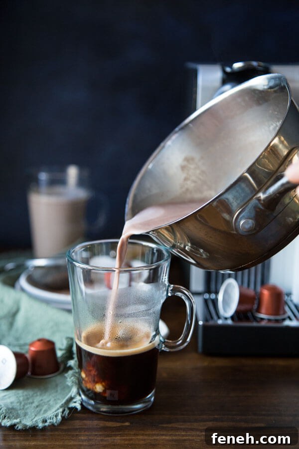 Pouring hazelnut hot chocolate mixture into a coffee mug