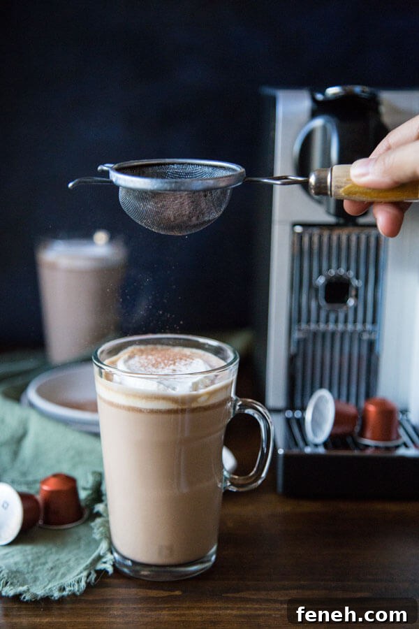 Adding cocoa powder to a mug of chocolate hazelnut latte