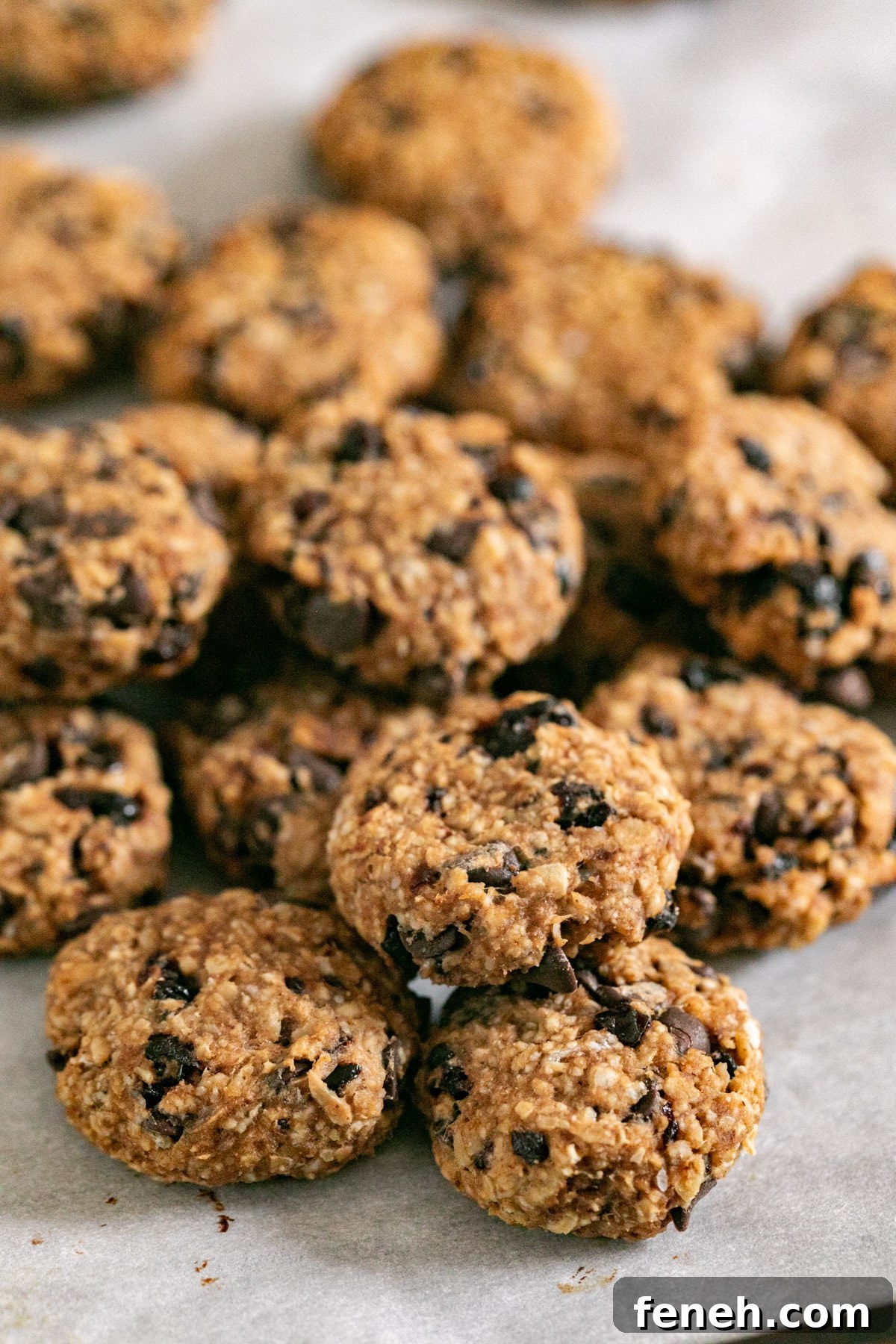 A pile of breakfast cookies on a parchment lined pan.