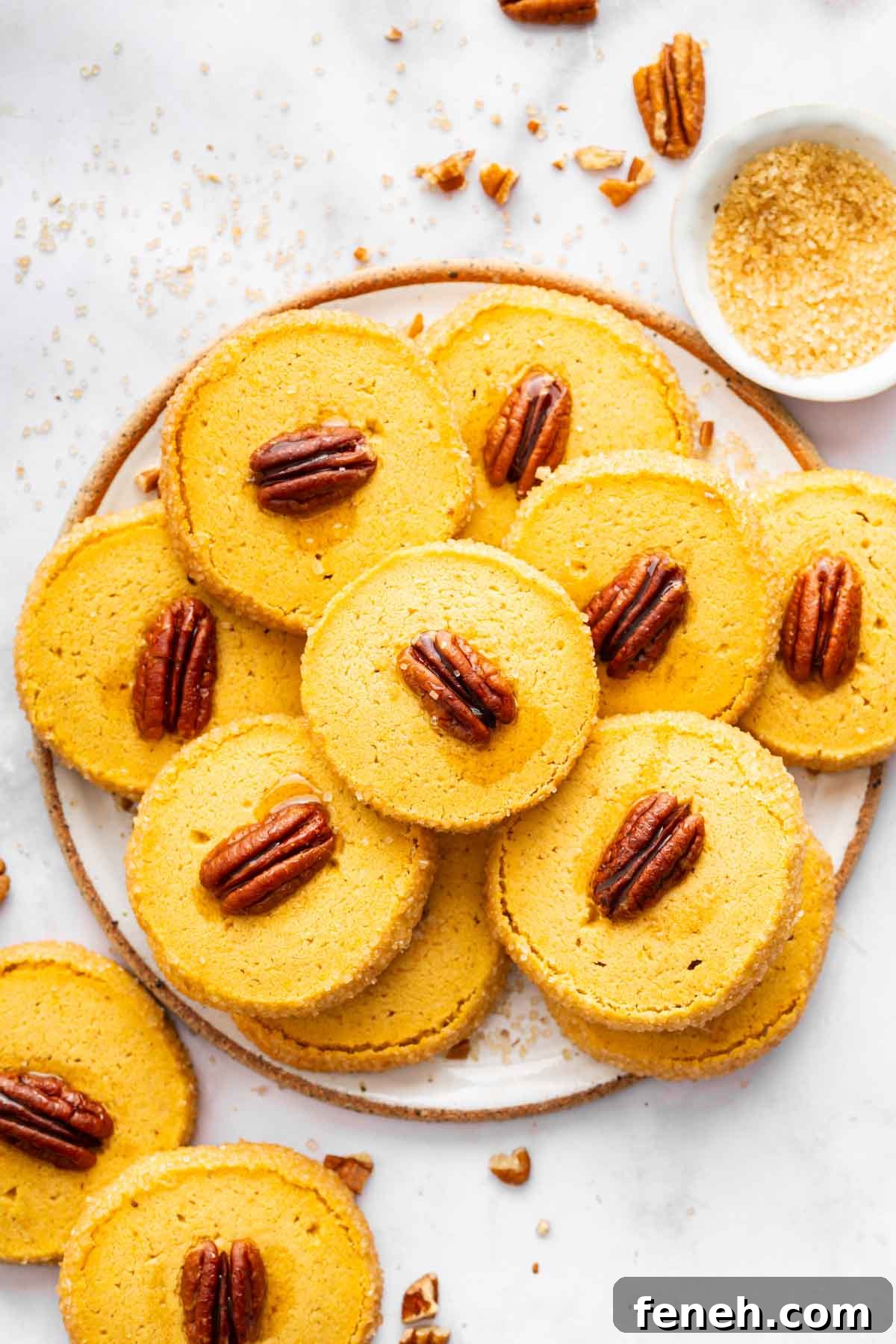 Orange pecan topped cookies on white round plate.